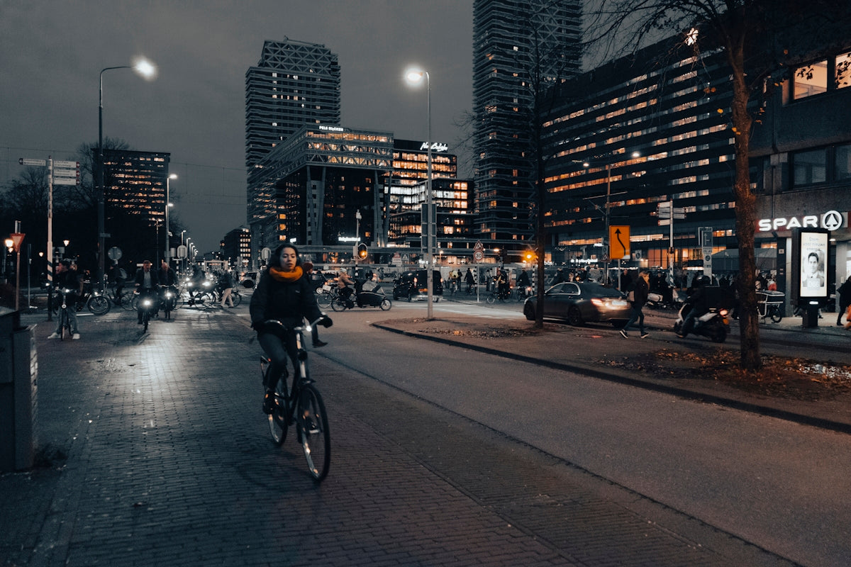 a man riding a bike down a street next to tall buildings